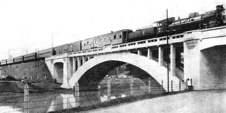 The Batavia-Djokja express crossing a concrete viaduct near the Weltevreden Station, Java