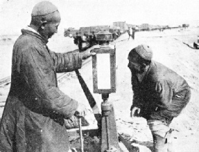 ASIATIC RAILWAY WORKERS examining the points on a stretch of track in Manchuria.