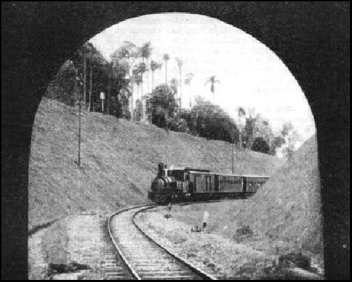 A PASSENGER TRAIN about to enter a tunnel near Tjitjoeroeg, Java